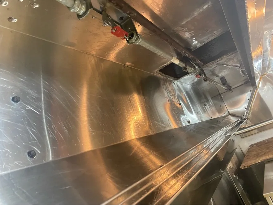 Inside of a kitchen hood cleaned back to bright stainless steel