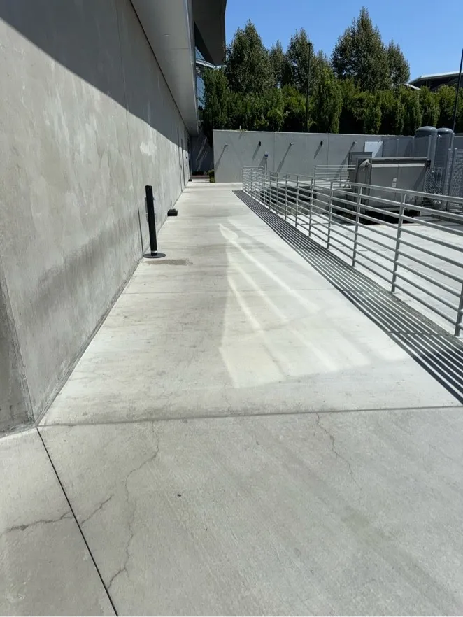 Concrete walkway and ramp beside an office building after pressure washing